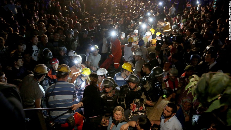 A massive crowd watches as rescuers work into the night.