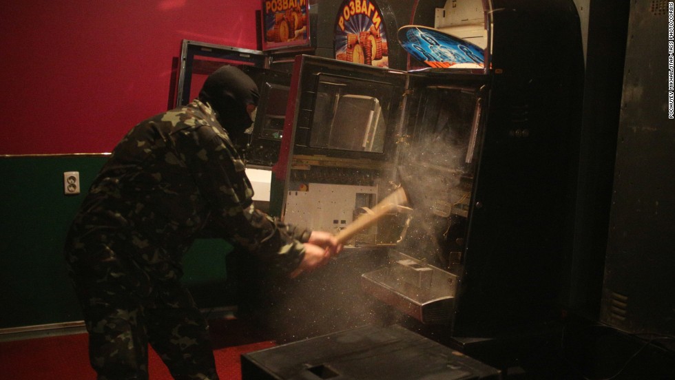A member of a &quot;self-defense&quot; squad smashes a slot machine with a sledgehammer Monday, May 12, at an illegal club in Slovyansk.