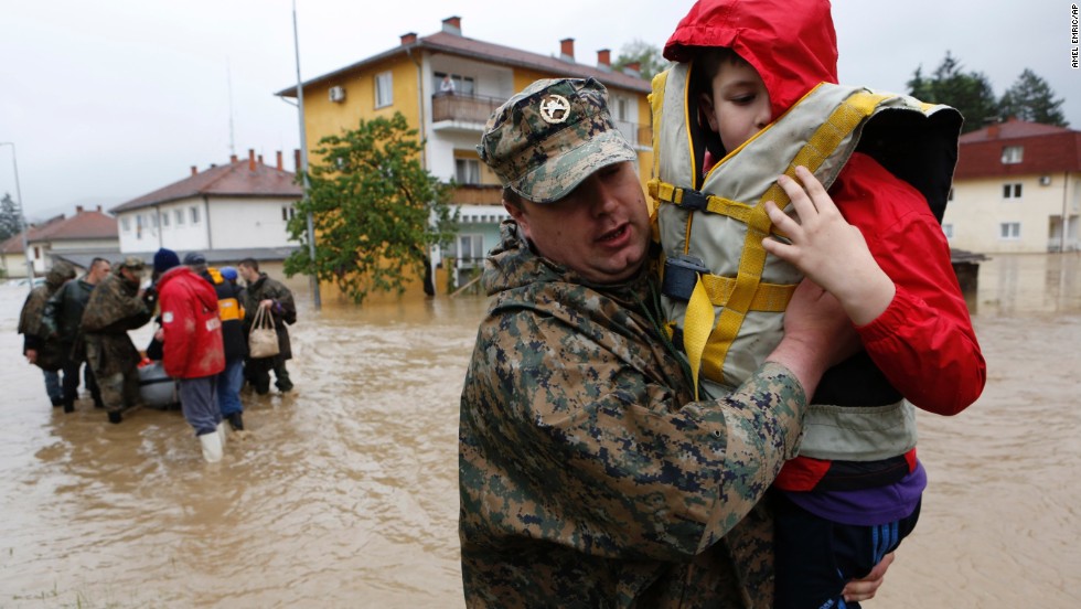 A member of the Bosnian army carries a boy rescued from his home May 16 in the town of Maglaj.