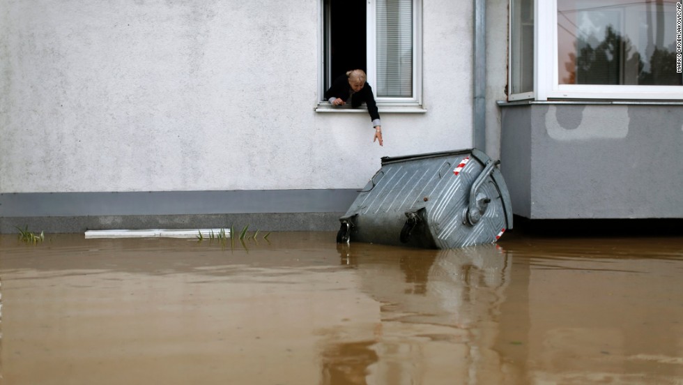 A woman tries to reach a trash container floating in the floodwaters in Obrenovac on May 16.