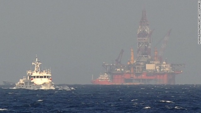 This picture taken on May 14, 2014 from a Vietnamese coast guard ship shows a Chinese coast guard vessel, left, sailing near China&#39;s oil drilling rig in disputed waters in the South China Sea. 