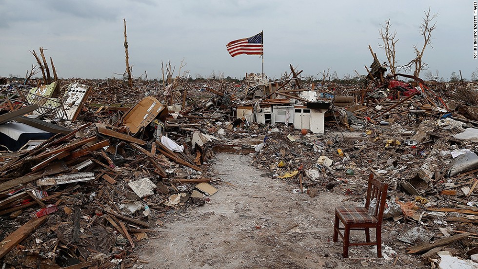 A massive tornado hit Moore, Oklahoma, on May 20, 2013, killing 24 people and causing an estimated $2 billion in property damage. Photographs taken then and now reveal the progress that has been made one year on. Here, an American flag flies over the rubble of a destroyed neighborhood in Moore on May 24, 2013. 