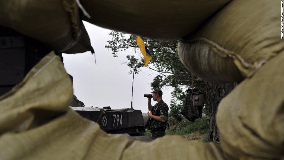 A Ukrainian soldier stands guard on the road from Izium, Ukraine, to Slovyansk on Monday, May 19.