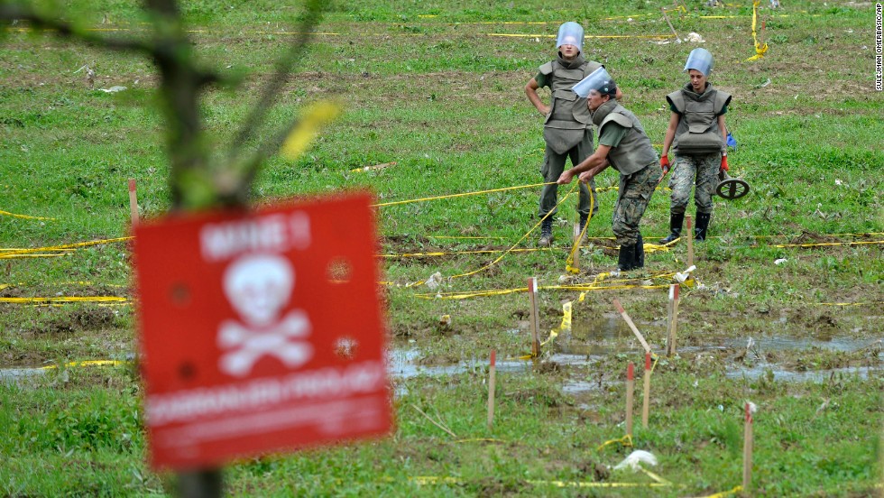Bosnian soldiers repair land-mine warning signs in fields near the banks of the Bosnia River, which flooded near the town of Visoko, Bosnia-Herzegovina, on May 20. 