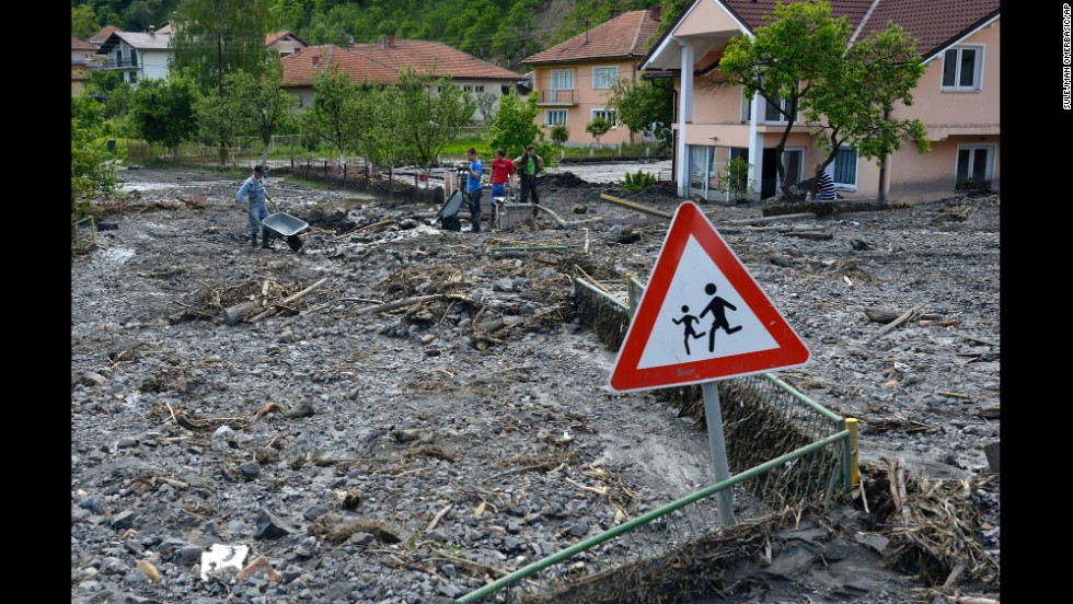Residents clean streets of mud and rubble after a landslide in Topcic Polje, Bosnia-Herzegovina, on Tuesday, May 20.