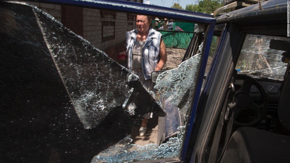 A woman walks past a destroyed car after Ukrainian government forces fired mortar shells during clashes with pro-Russian forces in Slovyansk, Ukraine, on May 23.