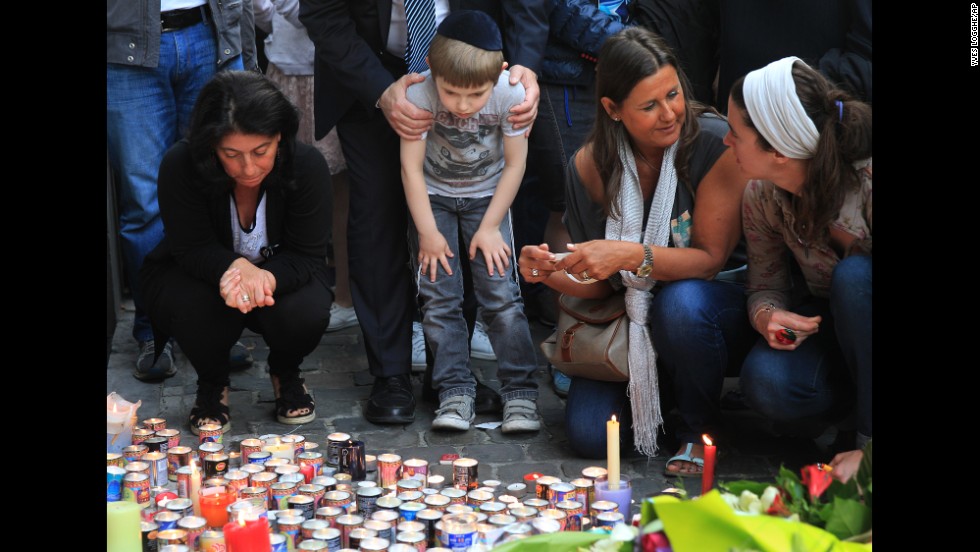 Three people were killed and a fourth was critically injured in the May 24 shooting. Here, people pay their respects Sunday, May 25, in front of a makeshift memorial at the entrance of the museum.