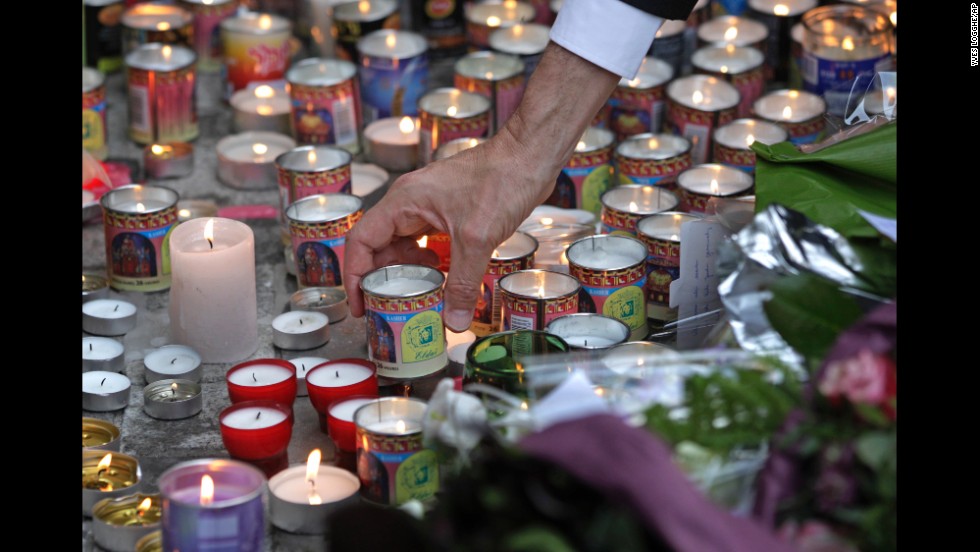 A man places a candle in front of the entrance of the museum on May 25.