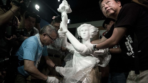 Today, Hong Kong is the only Chinese territory where commemoration of the June 4 crackdown is allowed. Here, pro-democracy legislator Lee Cheuk-yan (left) unwraps a replica of the Goddess of Democracy at Hong Kong's June 4 Museum that opened on April 24, 2014.