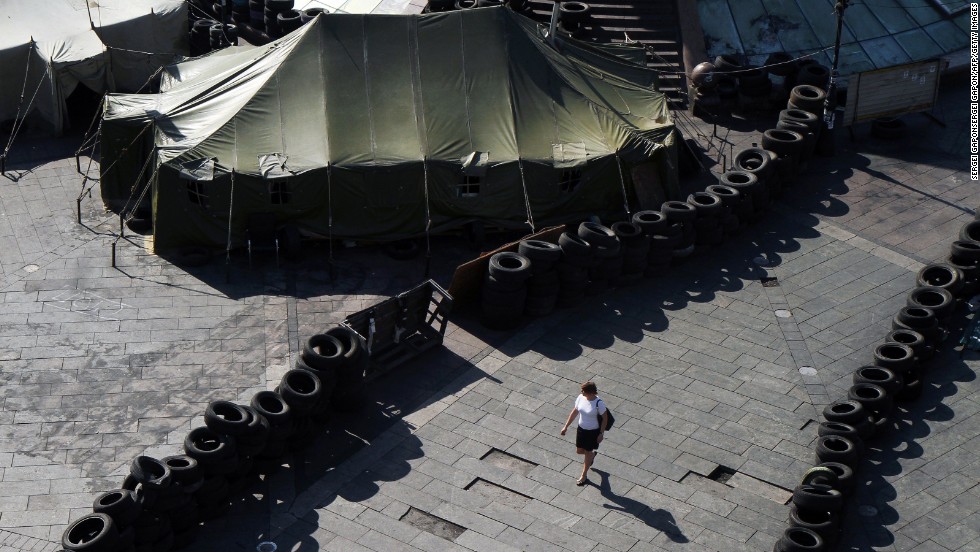 A woman walks May 26 near barricades built by protesters in Kiev&#39;s Independence Square. Vitali Klitschko, Kiev&#39;s future mayor and a former boxing champion, promised to dismantle the iconic protest encampment that helped oust Yanukovych but now clogs traffic and draws public complaints.
