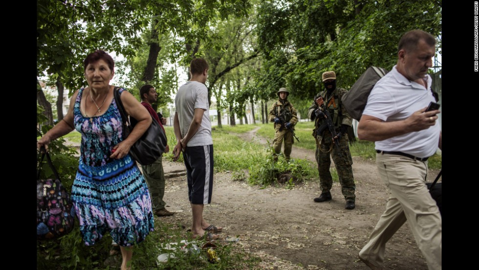 Men stand next to pro-Russian militants as a woman runs away during clashes near the airport on May 26.