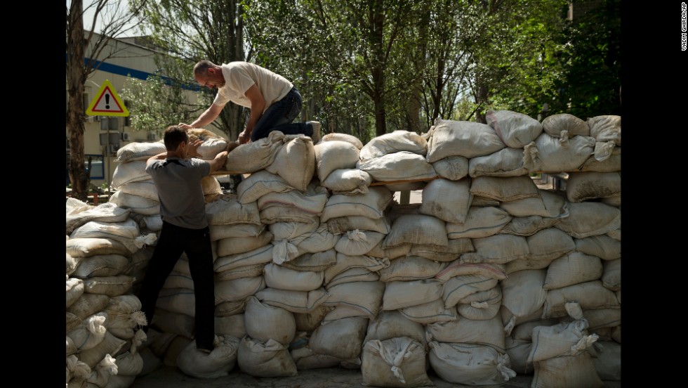 People pile up sandbags to set up a shooting position on the road leading from the Donetsk airport on May 27. 