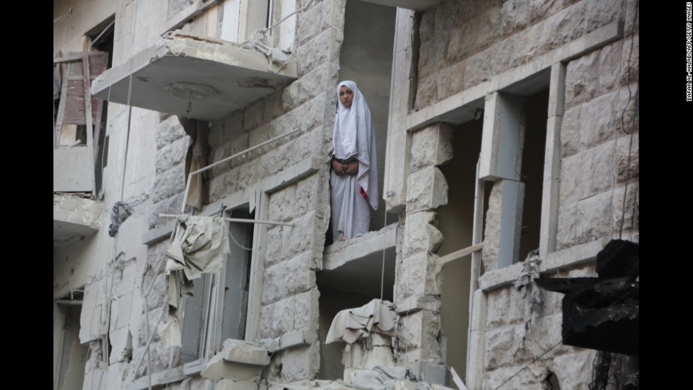 A woman stands in a heavily damaged building in Aleppo on May 26.