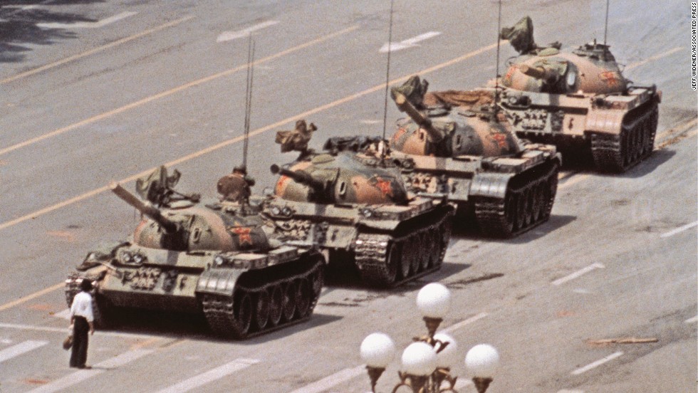 A lone man with shopping bags temporarily stops the advance of Chinese tanks after the bloody crackdown against protesters, Beijing, June 5, 1989. 