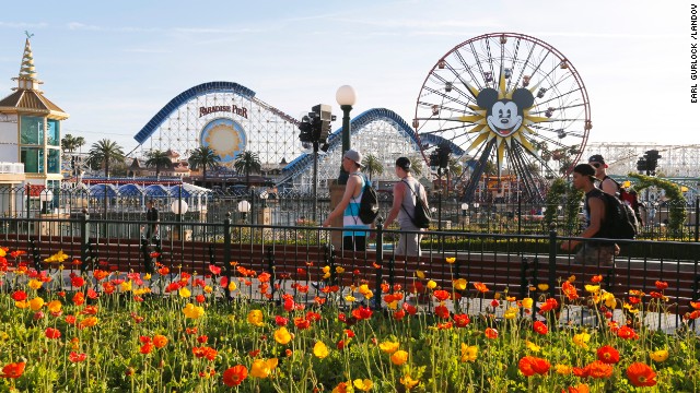 Image #: 28794655    People walk on the Paradise Pier as Mickey&#39;s Fun Wheel and the  California Screamin&#39; roller coaster sit in the background at Disney&#39;s California Adventure park on April 8, 2014 in Anaheim, California.    Earl Gurlock /Landov