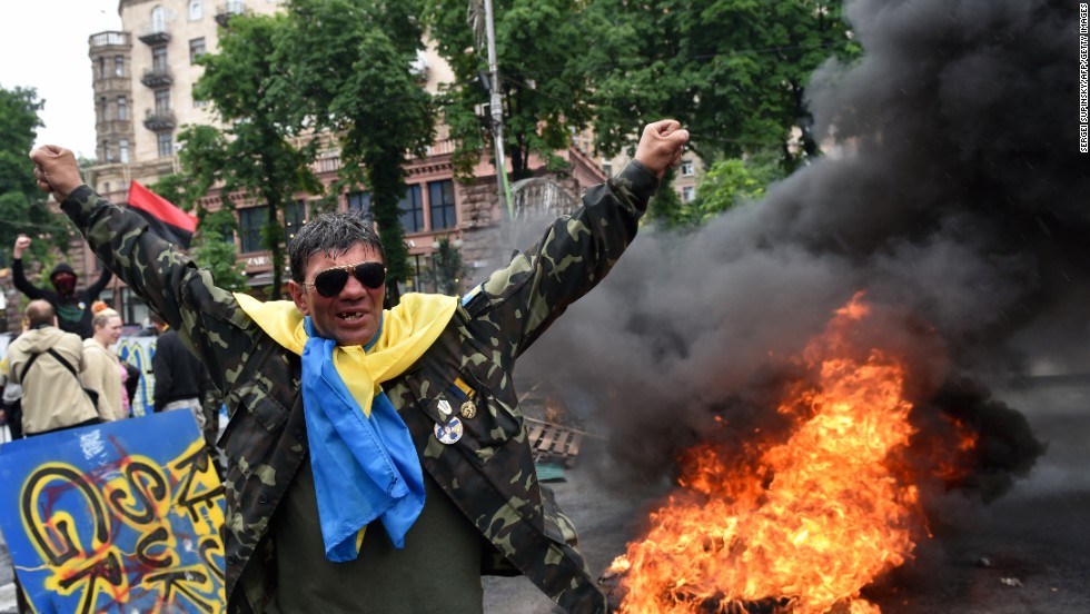 A protester from Kiev&#39;s Independence Square gestures May 31 as fellow protesters burn tires to protect their barricades from being dismantled by communal services.