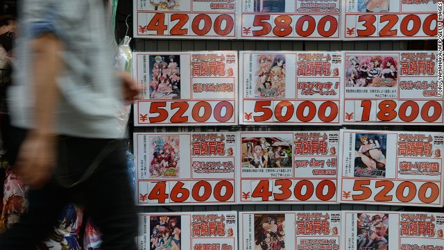 A man walks past advertisement of porn animation games in front of a second-hand DVD shop in Tokyo on June 4, 2014. 