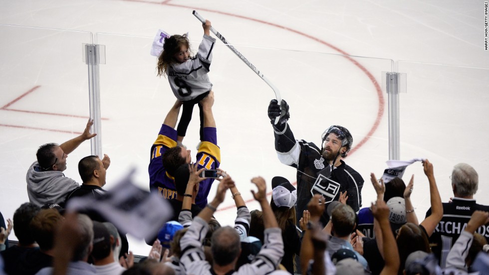 Justin Williams of the Los Angeles Kings hands his stick to a young fan after he scored the game-winning goal in Game 1 of the NHL&#39;s Stanley Cup Final. The Kings are looking to win their second Stanley Cup in three years.
