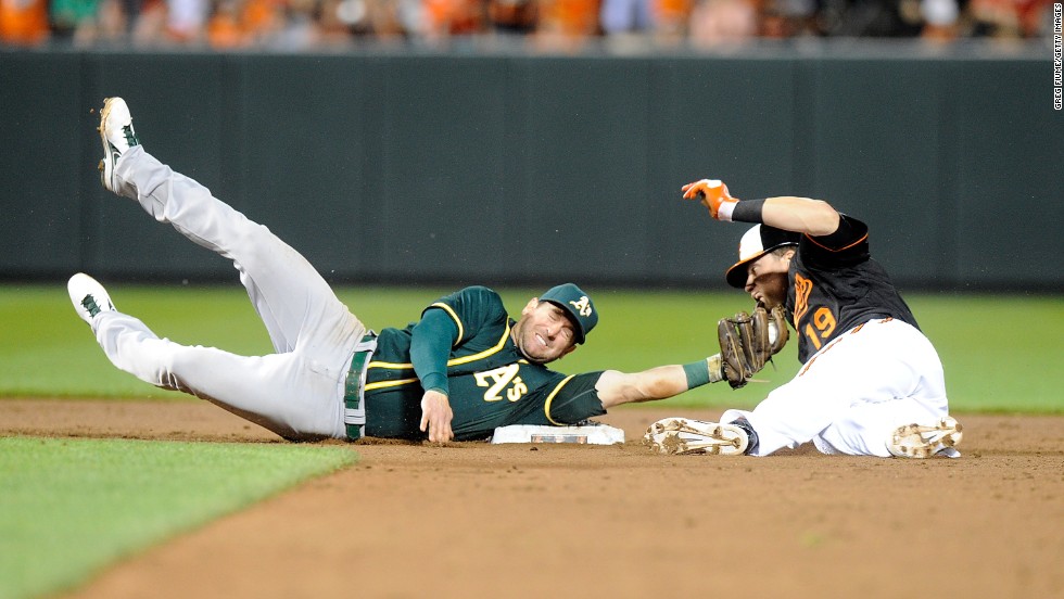 Oakland&#39;s Nick Punto stretches to tag Baltimore&#39;s Chris Davis during a slide into second base Friday, June 6, in Baltimore. Oakland won the game 4-3.