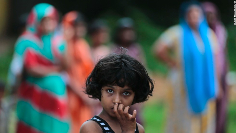 A  girl looks at a burned house in Aluthgama.