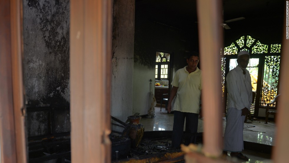 Sri Lankan residents survey the damage to a damaged Muslim-owned home.