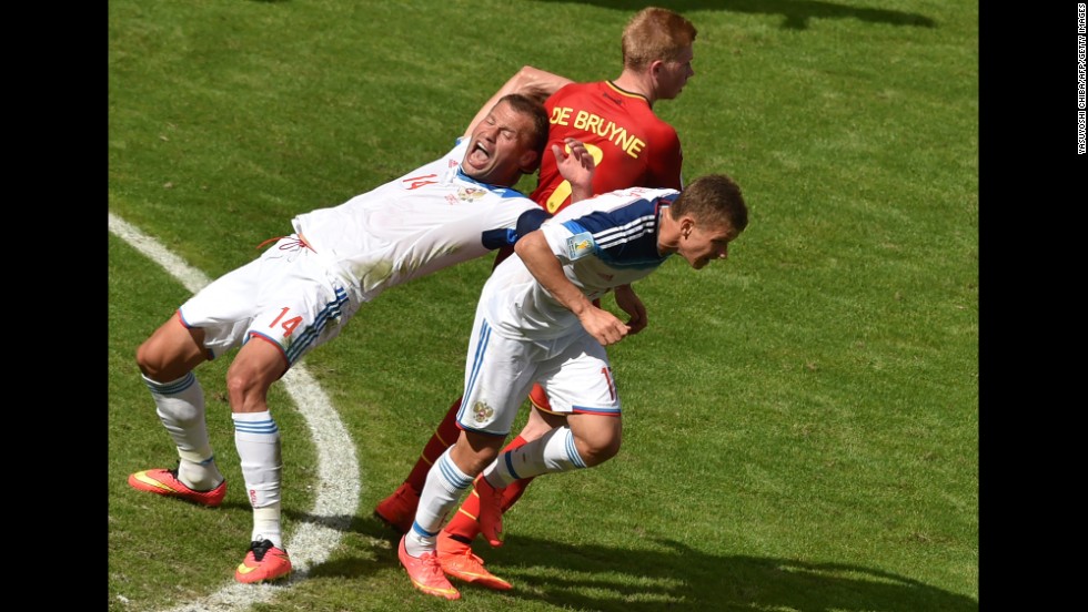 Belgium&#39;s midfielder Kevin De Bruyne is challenged by Russia&#39;s defender Vasily Berezutskiy, left, and midfielder Oleg Shatov.