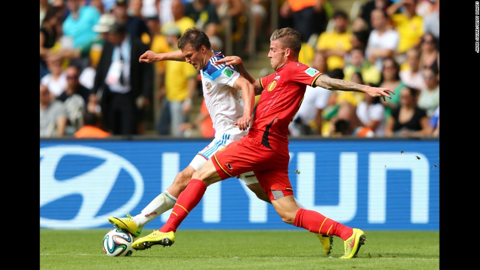 Toby Alderweireld of Belgium challenges Maksim Kanunnikov of Russia.