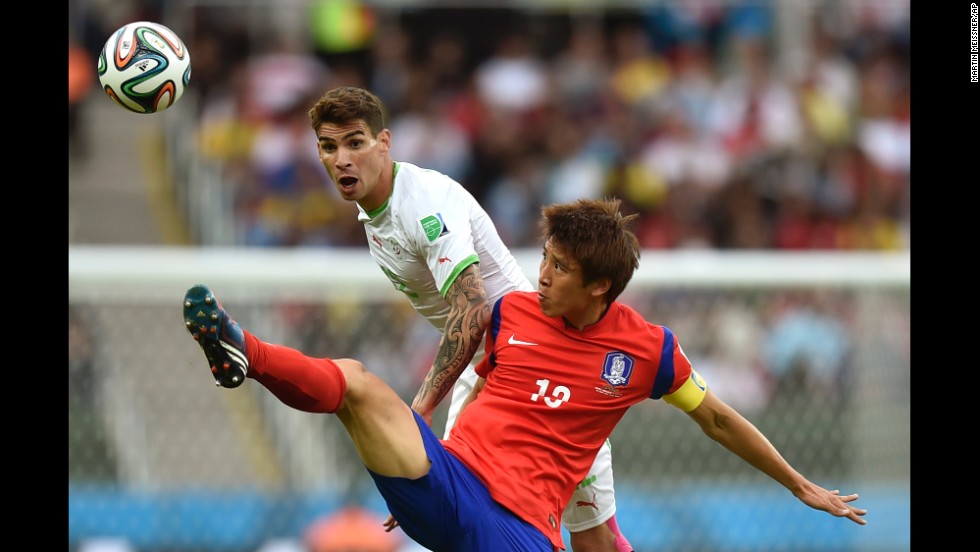 South Korea&#39;s Koo Ja-cheol reaches for the ball in front of Algeria&#39;s Carl Medjani.