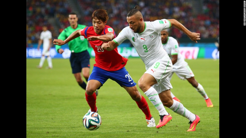 Hong Jeong-ho of South Korea and Nabil Ghilas of Algeria compete for the ball.