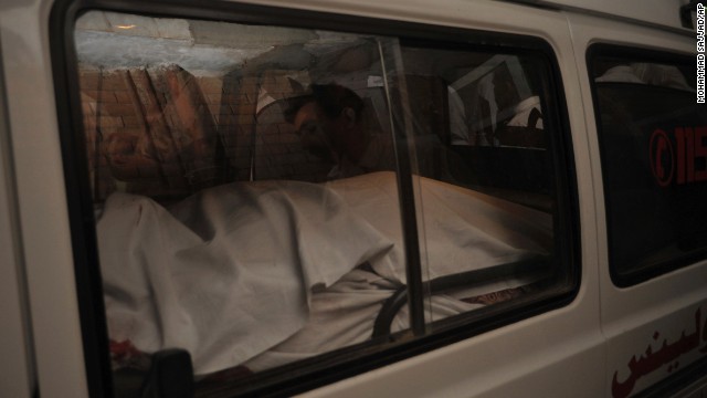 The dead body of a passenger killed in a Peshawar airport shooting is placed in an ambulance.