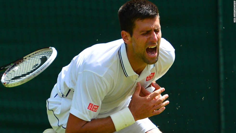 Novak Djokovic clutches his shoulder after an awkward fall during his third round match at Wimbledon.  