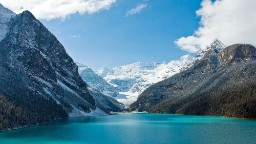 An alpine lake with sparkling blue waters, Alberta's Lake Louise in Banff National Park sits at the base of a cluster of glacier-clad peaks. The lake offers paddling in summer and an outdoor skating rink in winter. 