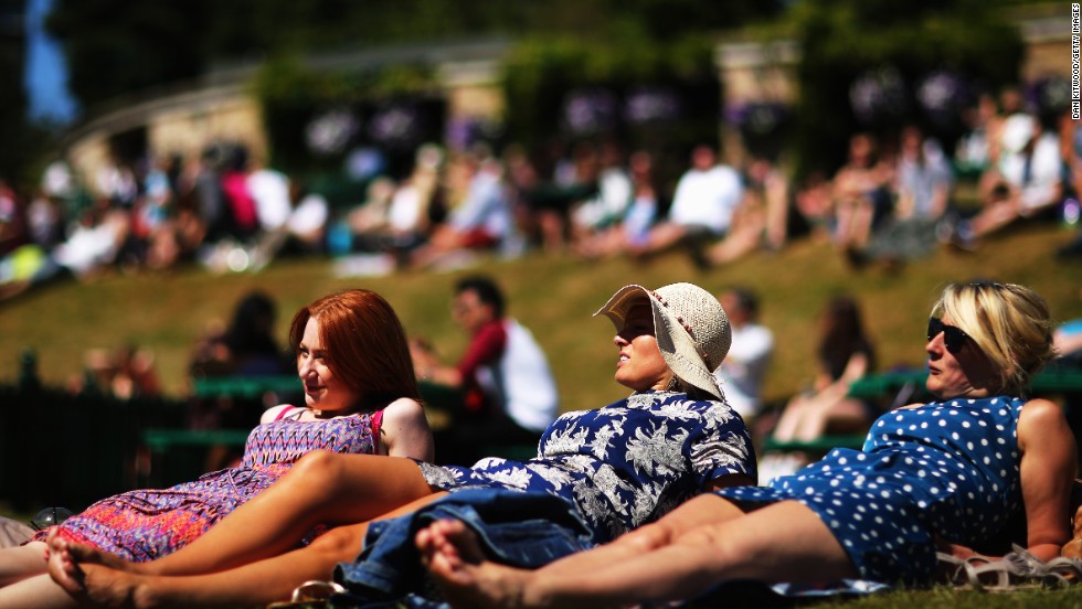 Spectators soak up some sun on &quot;Murray Mound&quot; in the grounds of the All England Club.
