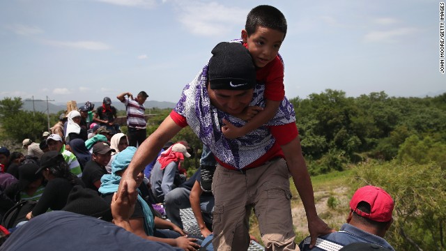 Caption:IXTEPEC, MEXICO - AUGUST 06: Central American immigrants arrive on top of a freight train for a stop on August 6, 2013 in Ixtepec, Mexico. Thousands of Central American migrants ride the trains, known as 'la bestia', or the beast, during their long and perilous journey north through Mexico to reach the United States border. Some of the immigrants are robbed and assaulted by gangs who control the train tops, while others fall asleep and tumble down, losing limbs or perishing under the wheels of the trains. Only a fraction of the immigrants who start the journey in Central America will traverse Mexico completely unscathed - and all this before illegally entering the United States and facing the considerable U.S. border security apparatus designed to track, detain and deport them. (Photo by John Moore/Getty Images)