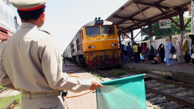 FILE PHOTO: A railway guard gives the green signal to a train in Thailand&#39;s southern Yala province.