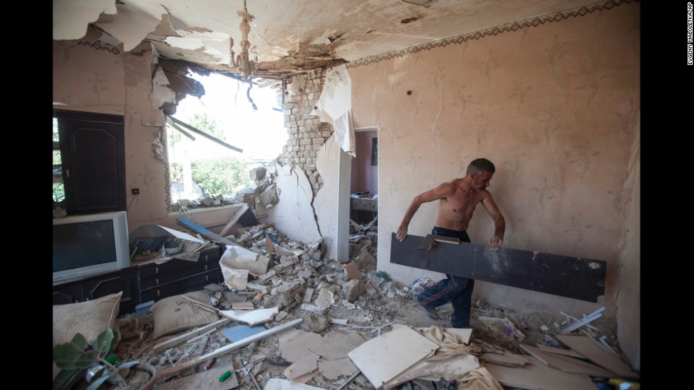 A man cleans up debris in his apartment after a shelling in Slovyansk on July 10.