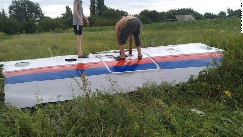 People inspect a piece of wreckage believed to be from Malaysia Airlines Flight 17. This image was posted to Twitter.