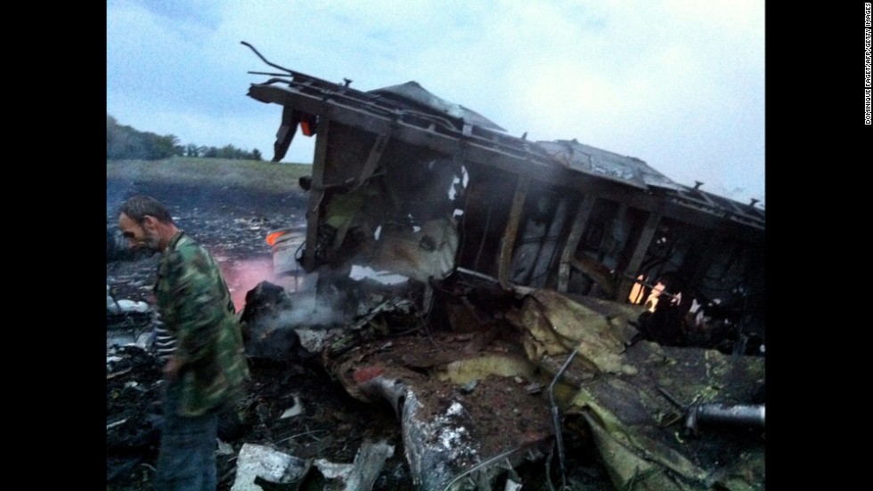 A man stands next to the wreckage of the airliner.