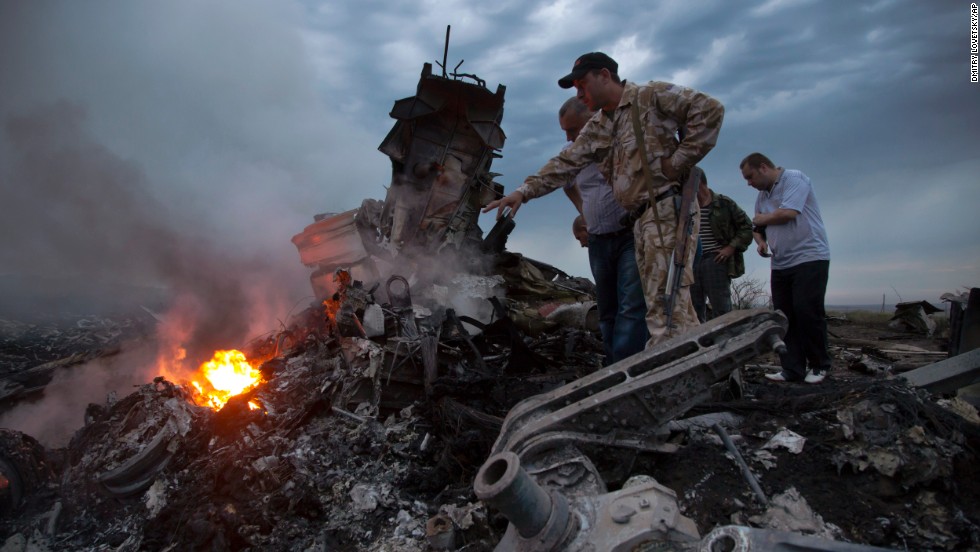 People inspect the crash site on Thursday, July 17, 2014.