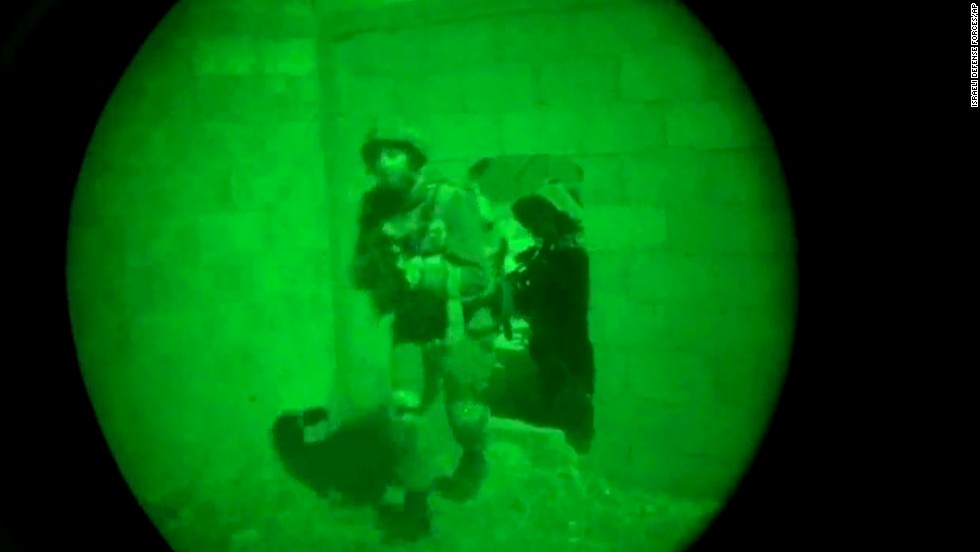 This image, made from video shot through a night-vision scope, was released by the Israeli military on July 18. It shows troops moving through a wall opening during the early hours of the ground offensive in Gaza. 