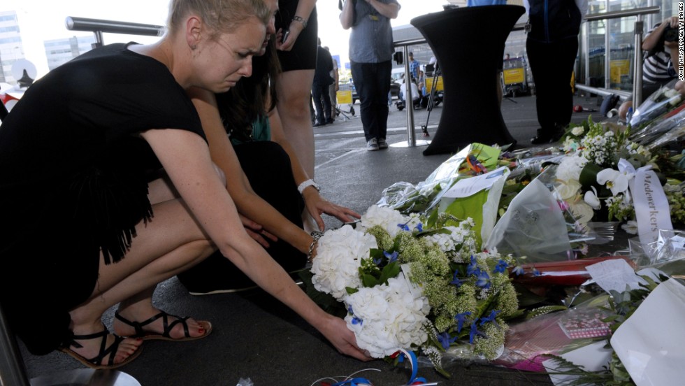 People lay flowers and light candles in front of the Schiphol airport on July 18.