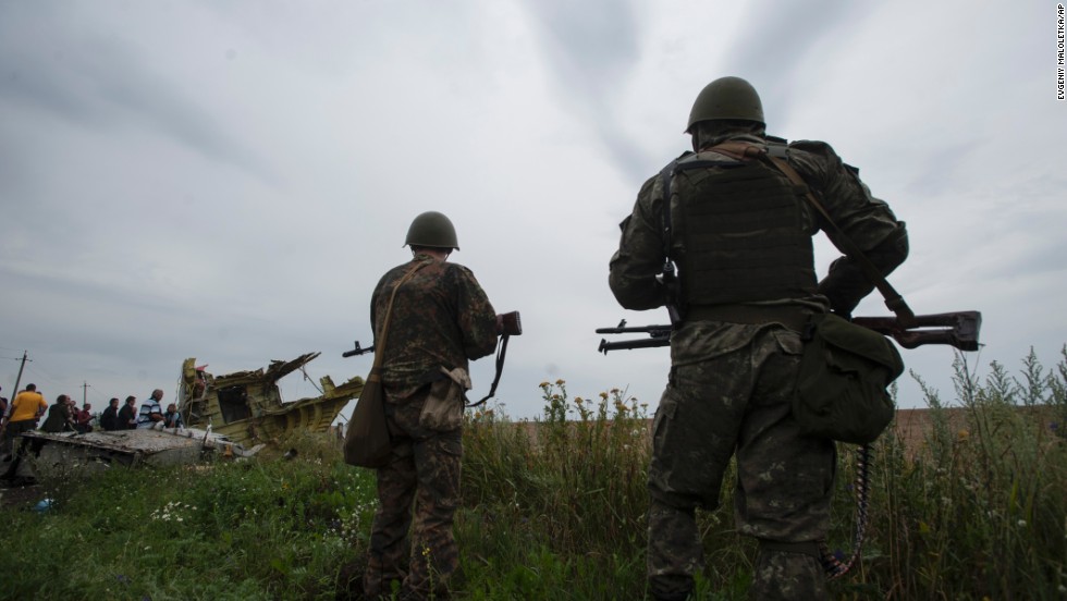 Pro-Russian rebels stand guard as the Organization for Security and Co-operation in Europe delegation arrives at the crash site on Friday, July 18, 2014. 