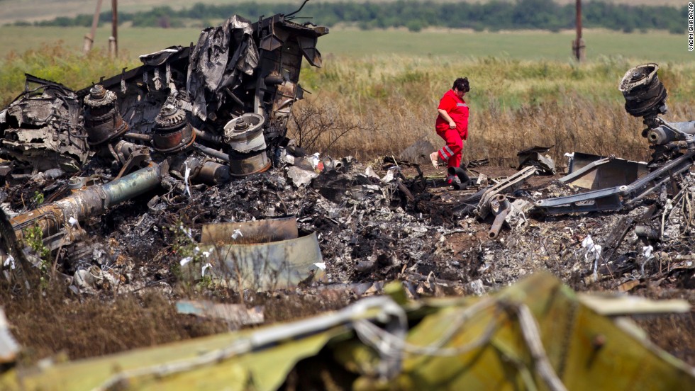 A woman walks among charred debris at the crash site on July 20, 2014.