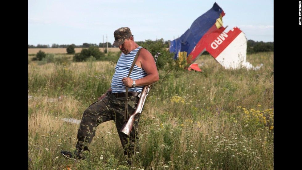 A pro-Russian rebel passes wreckage from the crashed jet near Hrabove on Monday, July 21, 2014.