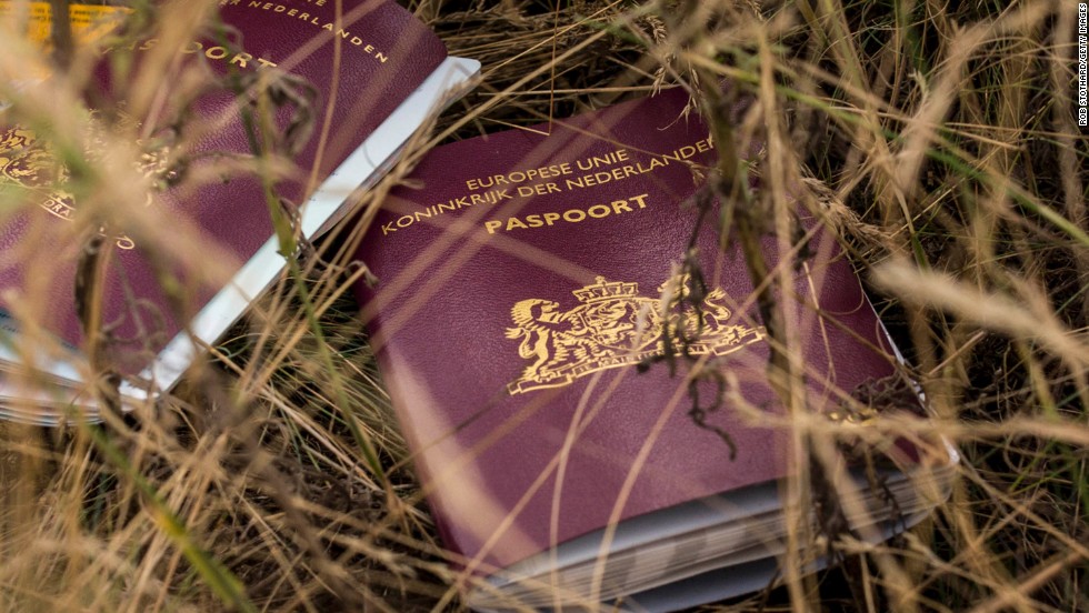 Two Dutch passports belonging to passengers lie in a field at the site of the crash on Tuesday, July 22.