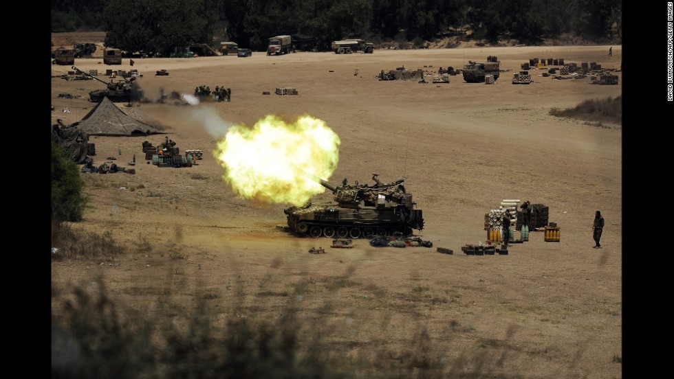 An Israeli tank fires toward Gaza from a position near Israel&#39;s border on July 24.