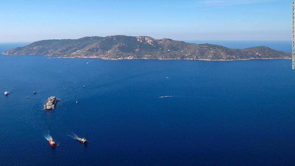 Tugboats tow the wreck of the Costa Concordia as it leaves Italy&#39;s Giglio Island on Wednesday, July 23. 