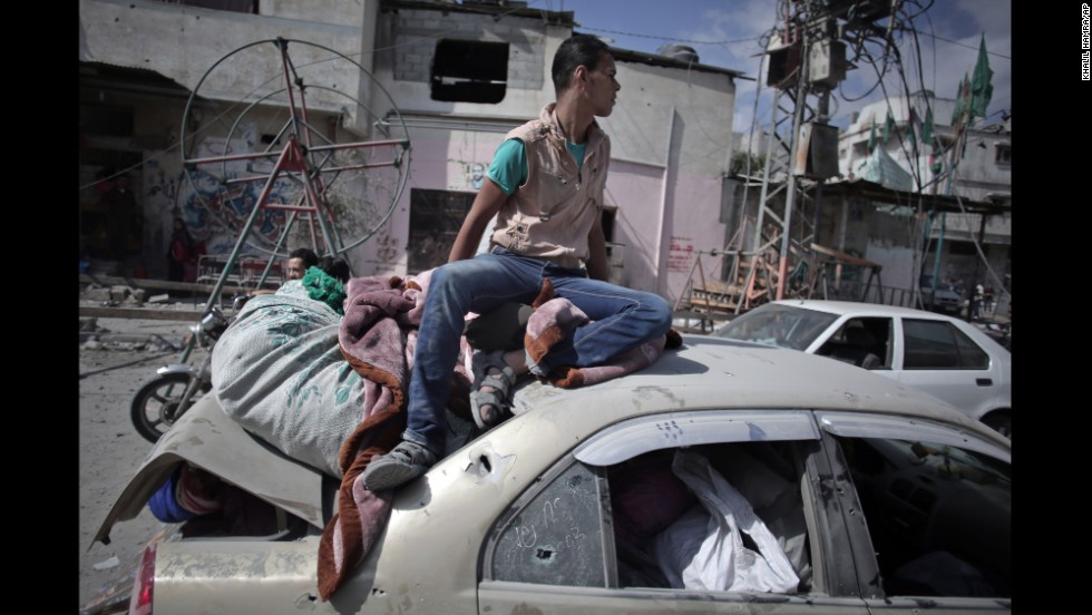 During a 12-hour cease-fire in Gaza City&#39;s Shijaiyah neighborhood on Saturday, July 26, a Palestinian man sits atop a car filled with belongings that were salvaged from a destroyed home.