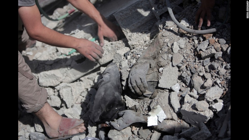 Palestinians dig a body out of the rubble of a destroyed house in Gaza during the cease-fire on July 26.