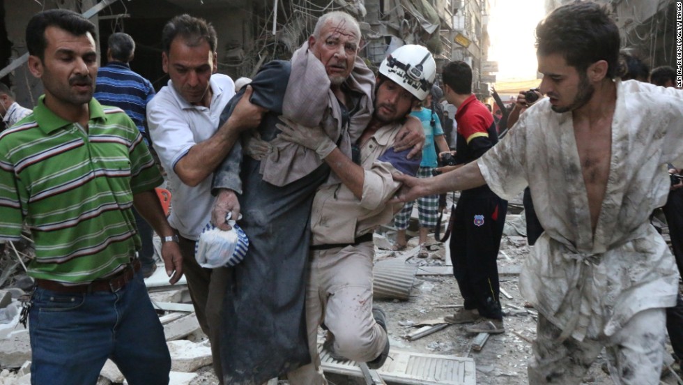 People carry an injured man away from the site of an airstrike, reportedly carried out by Syrian government forces, in Aleppo on Sunday, July 27.